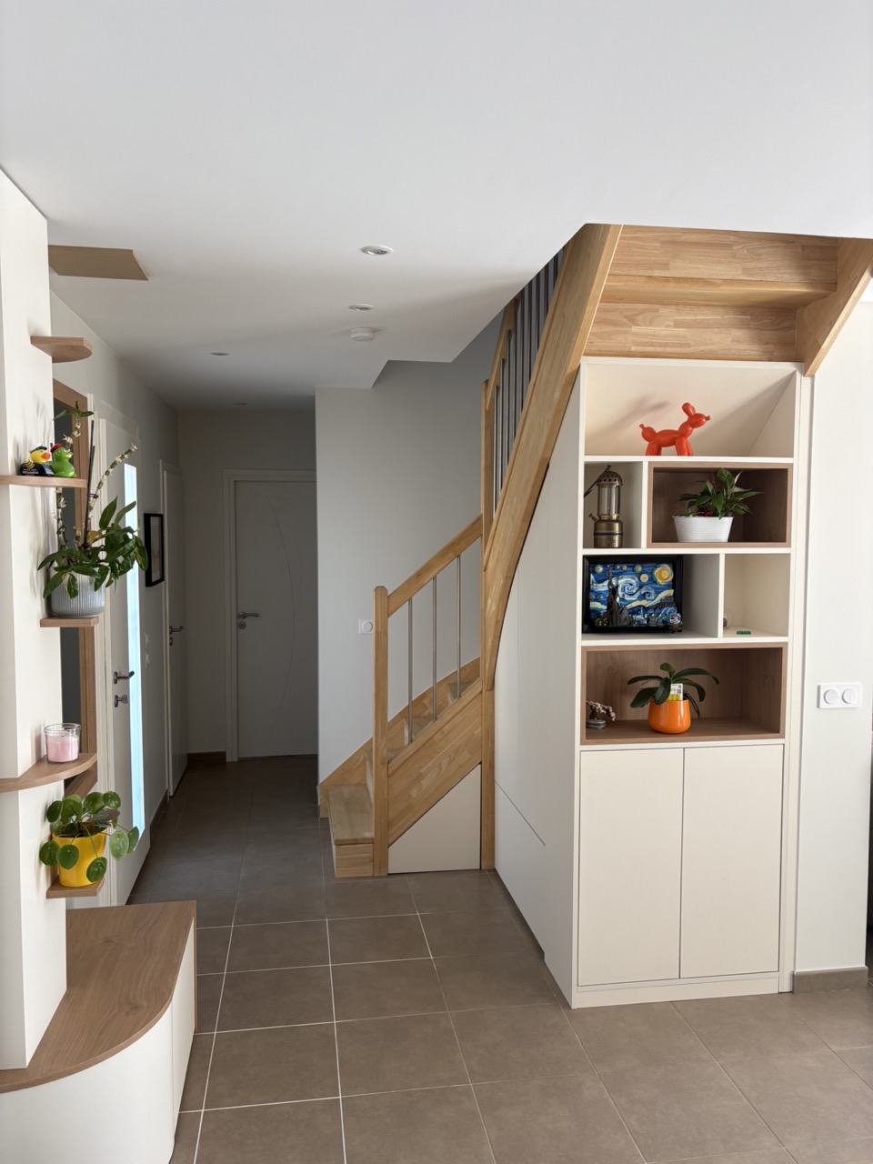 Espace entrée délimité par une arche avec claustra sur une assise et placard de rangement